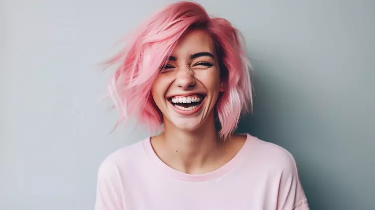 Young laughing woman with pastel pink hair, tongue sticking out, blue eyes, peace gestures funny facial expressions.