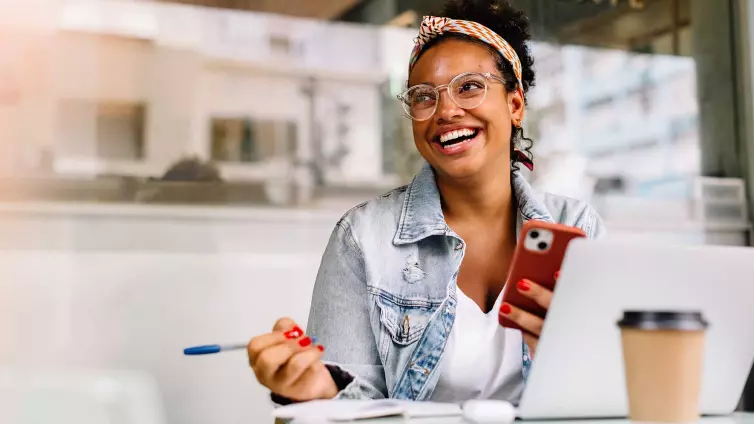 Woman laughing sat in a coffee shop.